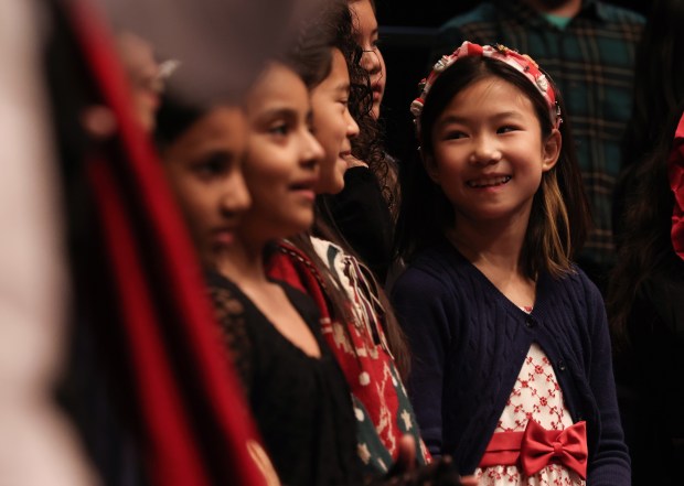 Choir student Valeria Huang, 9, smiles at fellow students in grades 3-5 while singing in the 61st annual Winter Arts Showcase at Jones College Prep. (John J. Kim/Chicago Tribune)