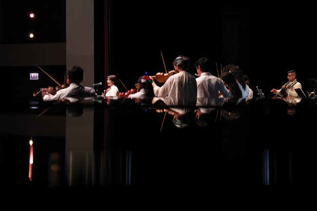 Mariachi students accompany Madeline Lopez, 17, second from left, as she sings a solo during the 61st annual Winter Arts Showcase on Dec. 14, 2024. (John J. Kim/Chicago Tribune)