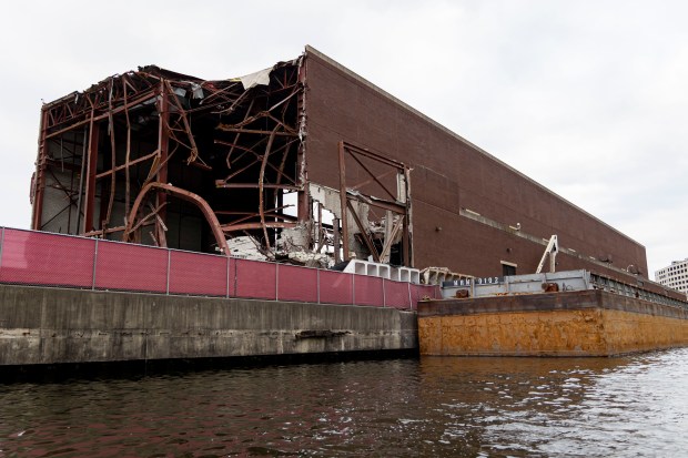 A barge sits along the Chicago River where demolition work is ongoing at the former Chicago Tribune Freedom Center on Dec. 18, 2024. (Brian Cassella/Chicago Tribune)