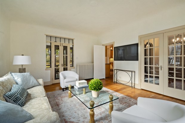 This six-bedroom, 5½-bath home at 312 Sterling Road, Kenilworth, features a living room with 10-foot ceilings, a stone fireplace and a dining area framed by three walls of windows. (Brad Schade)