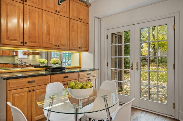 This six-bedroom, 5½-bath home at 312 Sterling Road, Kenilworth, features a living room with 10-foot ceilings, a stone fireplace and a dining area framed by three walls of windows. (Brad Schade)