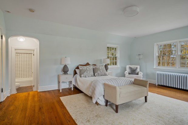 This six-bedroom, 5½-bath home at 312 Sterling Road, Kenilworth, features a living room with 10-foot ceilings, a stone fireplace and a dining area framed by three walls of windows. (Brad Schade)