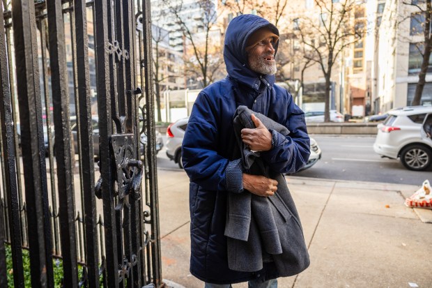 Terry Price smiles after receiving a winter coat from volunteers from The Chicago Help Initiative, an organization that provides meals and social services to those in need, outside Catholic Charities in the River North neighborhood of Chicago on Dec. 14, 2024. (Tess Crowley/Chicago Tribune)