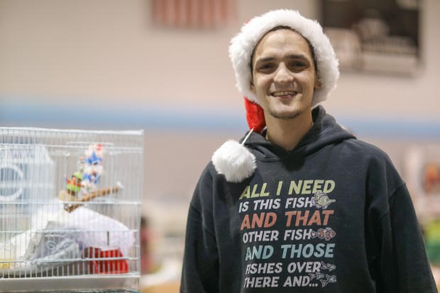 Adam Columbus, a fish hobbyist, poses for a portrait during Fins and Feathers Fest at Lions Recreation Center in Mount Prospect, Dec. 15, 2024. (Talia Sprague/for the Chicago Tribune)