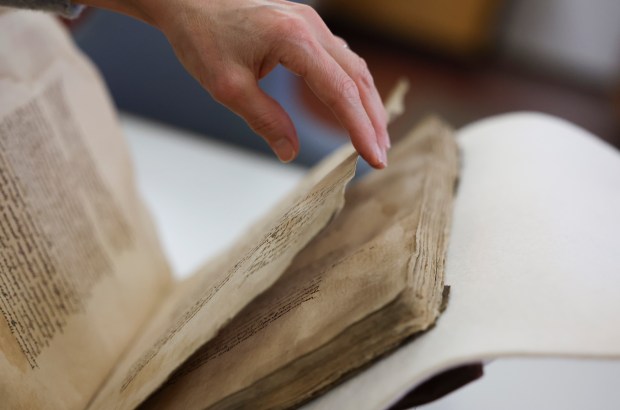 Director of Conservation Kim Nichols turns a page of Ayer 1485, a Nahuatl-language manuscript, in the conservation lab at Newberry Library, Dec. 11, 2024. (Eileen T. Meslar/Chicago Tribune)