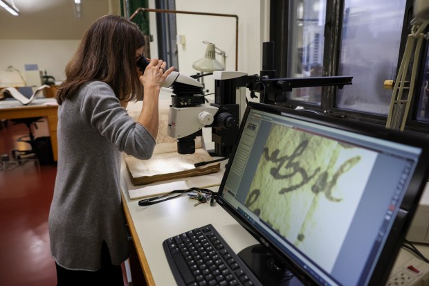 Director of Conservation Kim Nichols adjusts the microscope to view Ayer 1485, a Nahuatl-language manuscript, in the conservation lab at Newberry Library on the Near North Side, Dec. 11, 2024. (Eileen T. Meslar/Chicago Tribune)