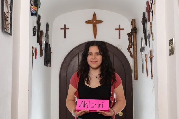 UIC freshman Ahtziri Arreola poses for a portrait with a nameplate of her name at home on Nov. 22, 2024. Ahtziri was given the name by her parents. It means "little drop of water" or "dewdrop" in Aztec. (John J. Kim/Chicago Tribune)