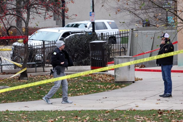 A police officer walks by a crime scene where Oak Park Police Detective Allan Reddins was killed on Nov. 29, 2024, near the main branch of the Oak Park public library. (Terrence Antonio James/Chicago Tribune)