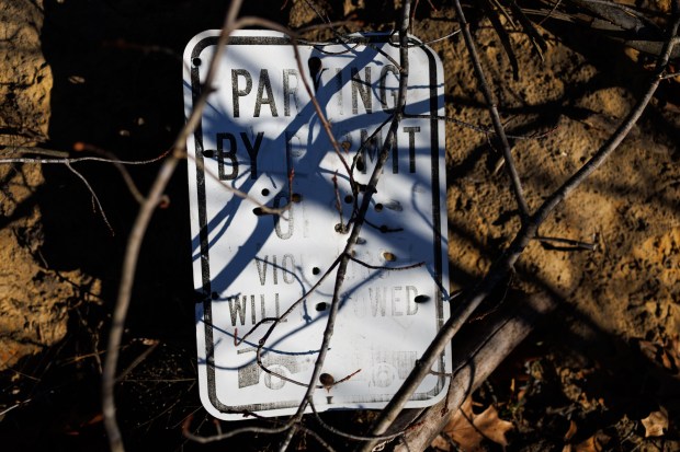 Bullet holes sit in a sign near a sand dune area located on private property behind local homes and used frequently by ATV's on Dec. 1, 2024, in Hopkins Park. (Armando L. Sanchez/Chicago Tribune)