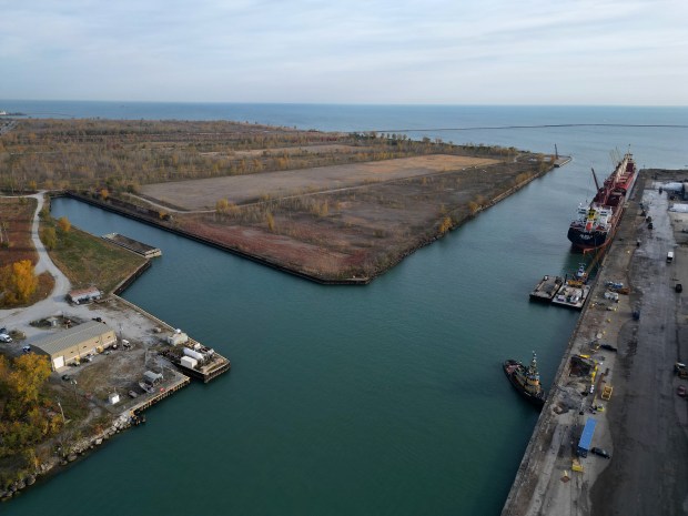 An empty parcel of land, the site of the former U.S. Steel South Works, sits across the Calumet River from two large ships on Oct. 22, 2024. The parcel of land is surrounded by water on three sides including Lake Michigan to the east and the Calumet River to the south. PsiQuantum has plans to anchor the new Illinois Quantum & Microelectronics Park, a 128-acre quantum campus on the border between Illinois and Indiana. (Stacey Wescott/Chicago Tribune)