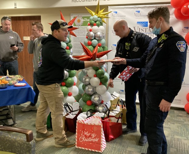 Waukegan firefighters talk about their efforts bringing Christmas gifts to children at Vista Medical Center East in Waukegan. (Steve Sadin/For the Lake County News-Sun)