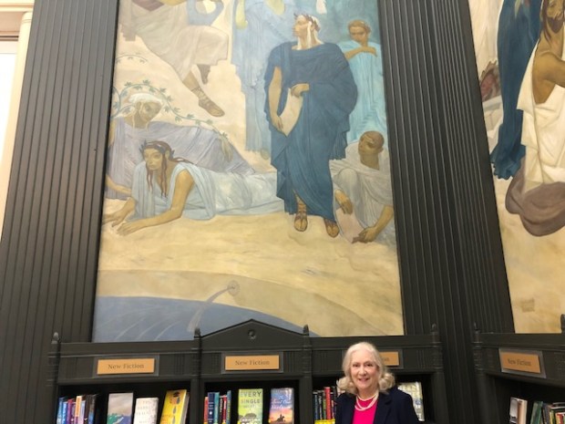 Friends of the Lake Forest Library board member Jan Gibson stands under a depiction of the writer Virgil at the Lake Forest Library by Russian artist Nicolai Remisoff. Gibson noted Remisoff drew a self-portrait in a light blue robe to the right of Virgil. (Daniel I. Dorfman/Pioneer Press)