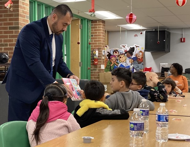 Oakdale Elementary School guest principal Germain Castellanos walks around the room as he reads to students. (Steve Sadin/For the Lake County-News-Sun)