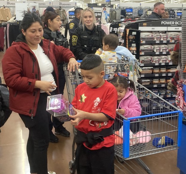 A young shopper looks at one of his new toys before checking out of the store at Shop With a Cop. (Steve Sadin/For the Lake County News-Sun)