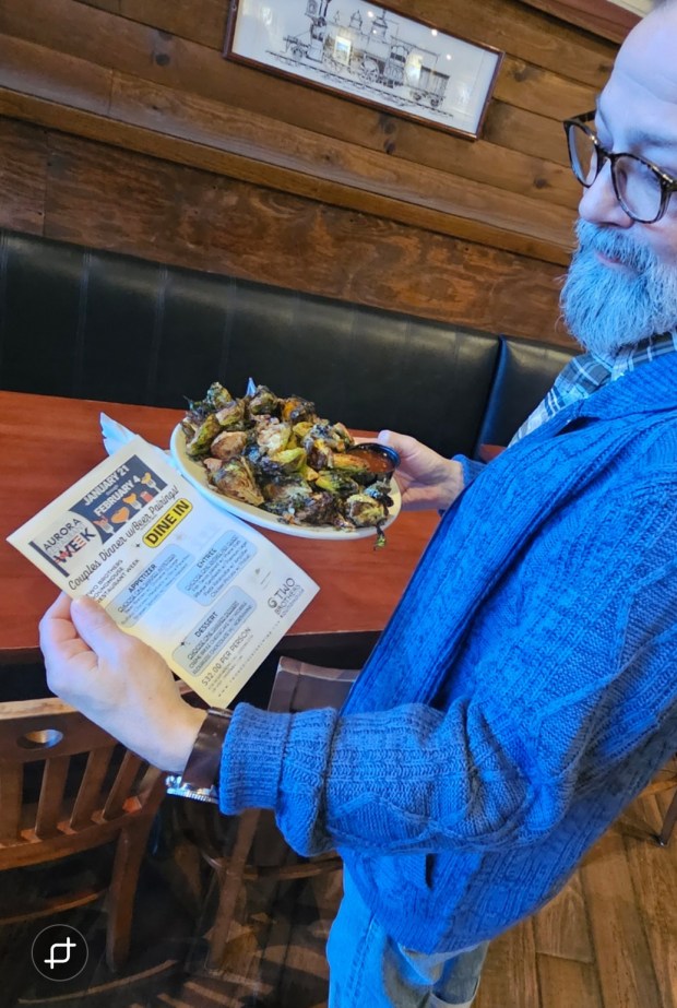 Two Brothers Roundhouse manager Kevin Trudo shows off some Brussels sprouts found on the Restaurant Week menu at the restaurant in Aurora. (David Sharos / For The Beacon-News)