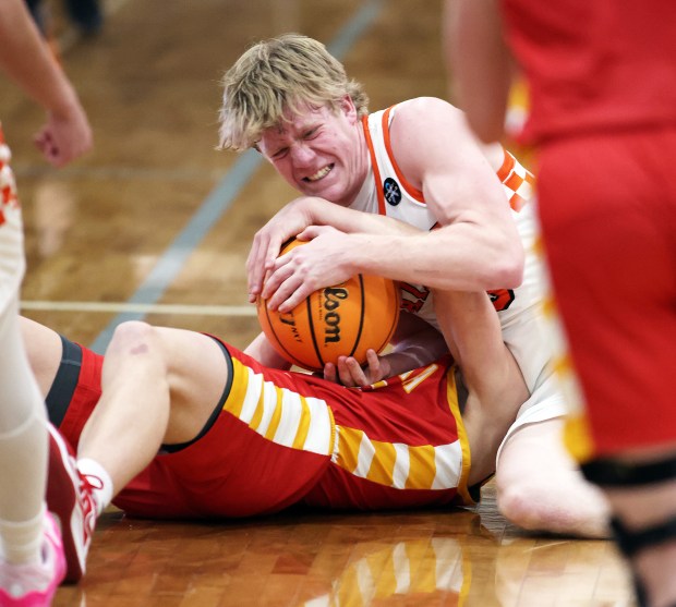 St. Charles East's Gavin Szerlong (10) and Batavia's Dane Farrar (15)wrestle for the ball in the fourth quarter during a DuKane Conference game in St. Charles on Friday, Jan. 10, 2025.H. Rick Bamman / For the Beacon News