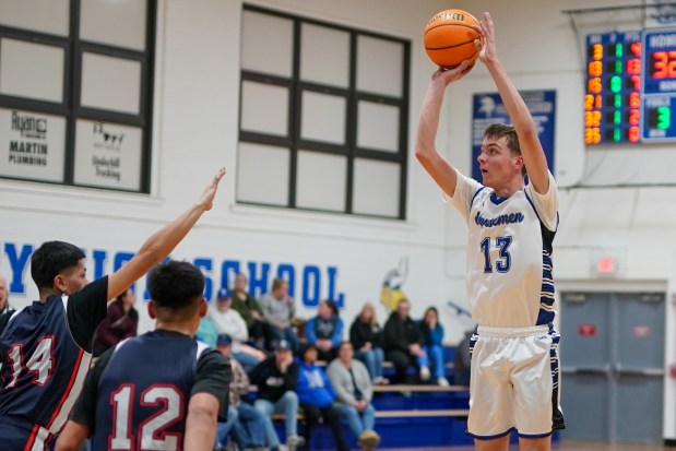 Newark's Dylan Long (13) shoots a three pointer against DePue's Pablo Escobar (14) during a basketball game at Newark High School on Tuesday, Jan. 14, 2025. (Sean King / for The Beacon-News)