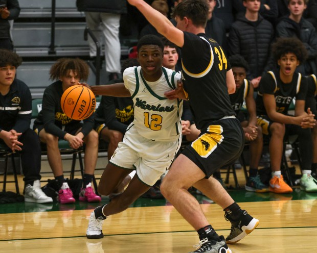 Waubonsie's Tyreek Coleman (12) drives to the net against Metea's Connor Lavery (34) during a basketball game in Aurora, Ill. on Friday, Jan. 24, 2025.(Mike Mantucca-For The Beacon-News)