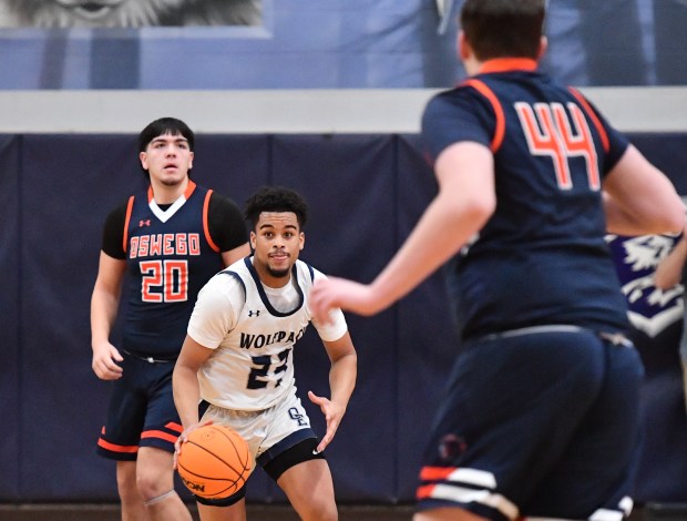 Oswego East's Torrin Ross drives the floor between Oswego defenders Michael Delgado (20) and Hunter O'Neill (44) during a game on Saturday, Jan. 11, 2025 in Oswego...(Jon Cunningham/for The Beacon-News)