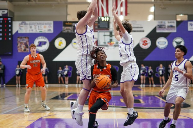 Sandwich's Simeion Harris (1) drives to the basket between Plano's Kevin Martinez (left), and Ethan Taxis during a Kishwaukee River Conference basketball game at Plano High School on Monday, Jan. 27, 2025. (Sean King / for The Beacon-News)