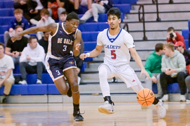 Marmion's Ali Tharwani (5) drives past St. Francis de Sales Marcus Halliburton (3) during a game at home in Aurora on Friday, Jan. 17, 2025. (Mark Black / for the Beacon-News)