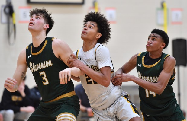 Metea Valley's CJ Jordan tangles for rebound position with Stevenson's Atticus Richmond (3) and Donovan Williams during a MLK Tournament game on Saturday, Jan. 18, 2025 in Wheaton...(Jon Cunningham/for The Beacon-News)