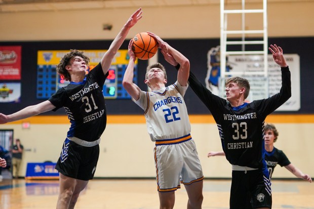 Aurora Central Catholic's Liam Schwartz (22) shoots the ball in the post against Westminster Christian's Zach Gurley (31) and Jake Arnold (33) during a basketball game at Aurora Central Catholic High School in Aurora on Monday, Jan. 9, 2017. (Sean King / for The Beacon-News)