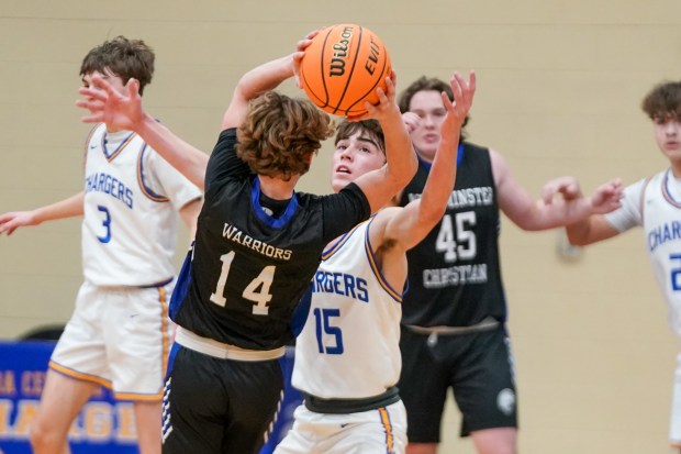 Aurora Central Catholic's Ben Bohr (15) defends the top of the key against Westminster Christian's Brain Powers (14) during a basketball game at Aurora Central Catholic High School in Aurora on Monday, Jan. 6, 2025. (Sean King / for The Beacon-News)