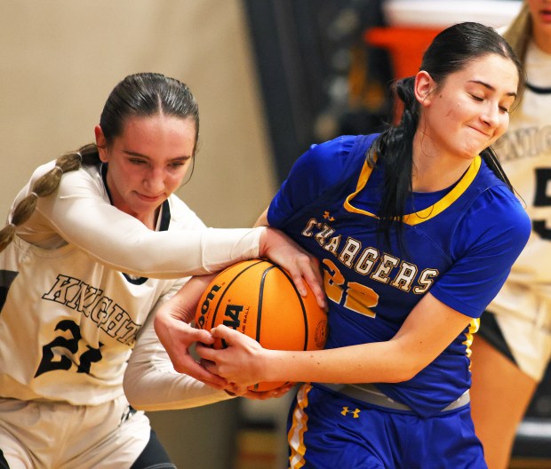 Kaneland's Kyra Lilly (21) and Aurora Central Catholic's Brooklyn Murphy (22) fight for the ball along the baseline in the second quarter during a non-conference game in Maple Park on Tuesday, Jan. 7, 2025.H. Rick Bamman / For the Beacon News