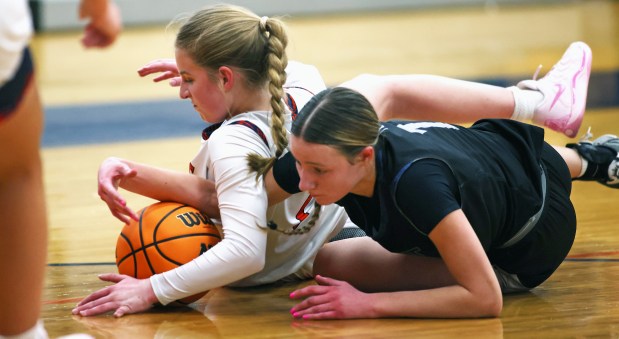 Oswego East's Aubrey Lamberti (1) right, and Oswego's Ashley Cook (2) tumble for the ball in the second quarter during a Southwest Prairie conference game in Oswego on Wednesday, Jan. 22, 2025.H. Rick Bamman / For the Beacon News