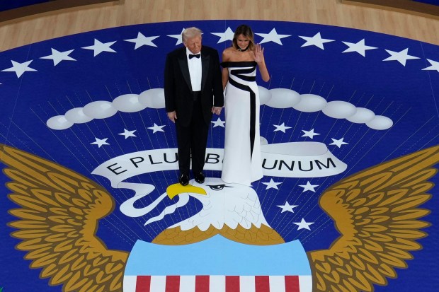 First lady Melania Trump waves as she stands with President Donald Trump before they dance at the Commander in Chief Ball, Monday, Jan. 20, 2025, in Washington. (AP Photo/Alex Brandon)