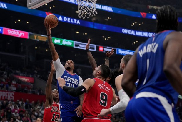 Clippers guard Norman Powell goes to the basket against the Bulls' Ayo Dosunmu and Nikola Vučević during the first half on March 9, 2024. (AP Photo/Eric Thayer)