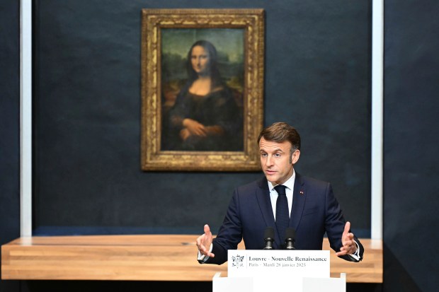 French President Emmanuel Macron gives a speech to announce a multi-year overhaul, long-term investments to modernize the Louvre museum, next to Leonardo da Vinci's painting of the Mona Lisa at the Louvre Museum, Tuesday, Jan. 28, 2025 in Paris. ( Bertrand Guay, Pool via AP)