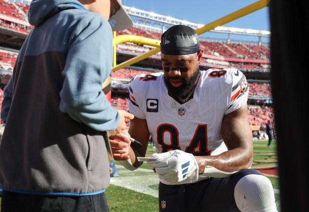 Bears tight end Marcedes Lewis signs an autograph on the field during warmups for a game against the 49ers at Levi's Stadium on Dec. 8, 2024, in Santa Clara. (John J. Kim/Chicago Tribune)