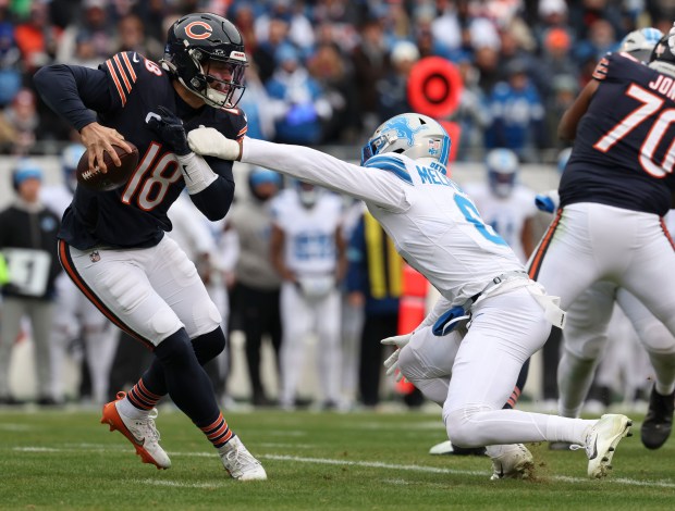 Chicago Bears quarterback Caleb Williams (18) scrambles under pressure from Detroit Lions safety Ifeatu Melifonwu (6) in the first quarter Sunday, Dec. 22, 2024, at Soldier Field. (Brian Cassella/Chicago Tribune)