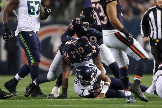 Chicago Bears defensive tackle Byron Cowart (93) tackles Seattle Seahawks quarterback Geno Smith (7) during the second quarter at Soldier Field Thursday Dec. 26, 2024, in Chicago. (Armando L. Sanchez/Chicago Tribune)