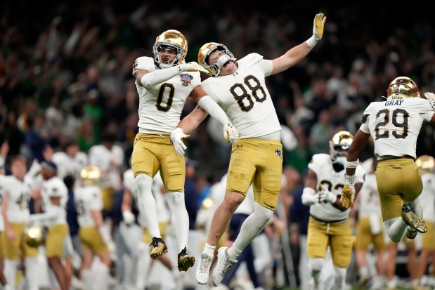 Notre Dame safety Xavier Watts (0) celebrates with teammate Armel Mukam during the second half against Georgia in a College Football Playoff quarterfinal Thursday, Jan. 2, 2025, in New Orleans. (AP Photo/Gerald Herbert)