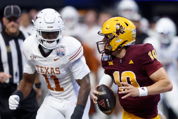 Arizona State quarterback Sam Leavitt scrambles away from Texas' Colin Simmons during the Peach Bowl on Jan. 1, 2025, in Atlanta. (Butch Dill/Getty Images)