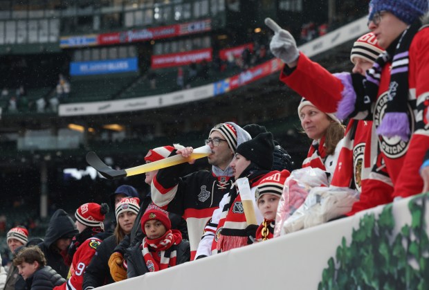 A fan drinks beer from a hockey stick-shaped cup before the NHL Winter Classic between the Blackhawks and Blues at Wrigley Field on Dec. 31, 2024, in Chicago. (John J. Kim/Chicago Tribune)