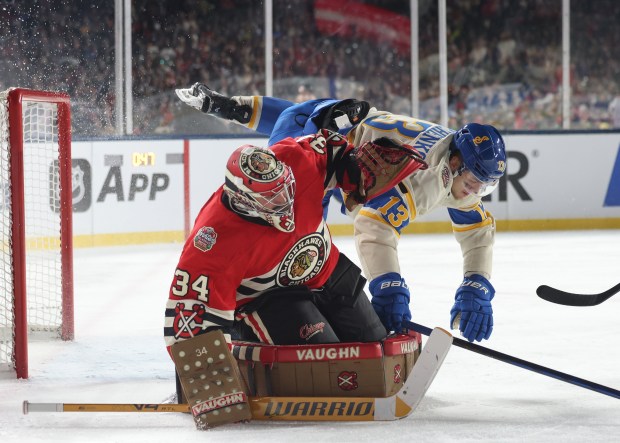 Blues right wing Alexey Toropchenko (13) skates into Blackhawks goaltender Petr Mrazek (34) in the second period of the NHL Winter Classic at Wrigley Field on Dec. 31, 2024, in Chicago. (John J. Kim/Chicago Tribune)