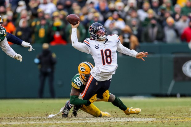 Green Bay Packers linebacker Edgerrin Cooper (56) tackles Chicago Bears quarterback Caleb Williams (18) while he tries to make a pass on the last drive on the game during the fourth quarter at Lambeau Field Sunday Jan. 5, 2025, in Green Bay, Wis. (Armando L. Sanchez/Chicago Tribune)