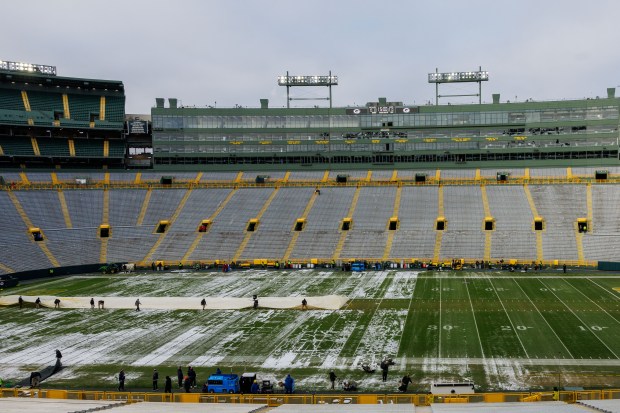 Workers clear snow off the field before the Chicago Bears play the Green Bay Packers at Lambeau Field in Green Bay. (Armando L. Sanchez/Chicago Tribune)