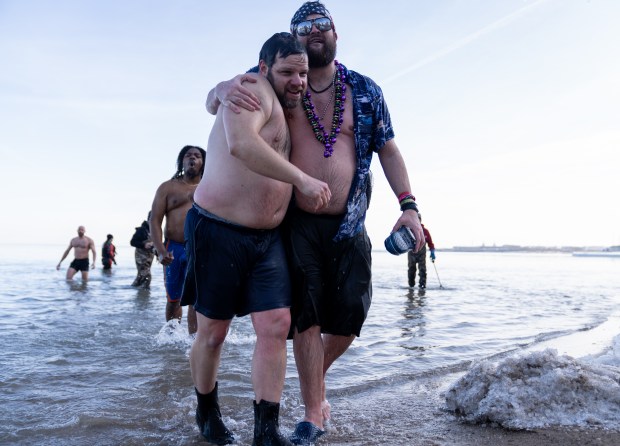 People embrace as they make their way out of Lake Michigan during Chicago Polar Bear Club's 24th annual Polar Plunge on Jan. 25, 2025. (Audrey Richardson/Chicago Tribune)