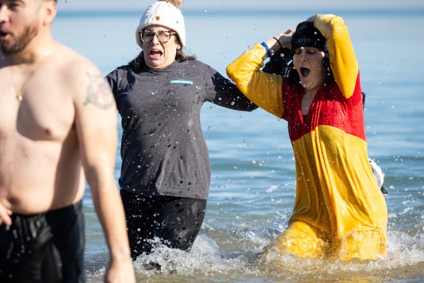 People plunge into Lake Michigan's cold temperatures during Chicago Polar Bear Club's 24th annual Polar Plunge at Oak Street Beach. (Audrey Richardson/Chicago Tribune)