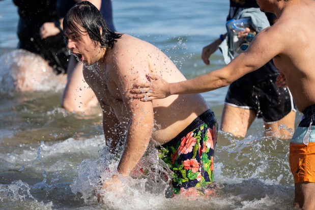 A person comes up for air after dunking into Lake Michigan after participating in Chicago Polar Bear Club's 24th annual Polar Plunge at Oak Street Beach on Jan. 25, 2025. (Audrey Richardson/Chicago Tribune)