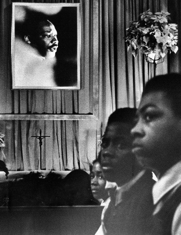 A portrait of Dr. Martin Luther King Jr. hangs above a memorial service for the slain civil rights leader at Holy Angels Catholic Church at 607 Oakwood Blvd. on Jan. 15, 1974, in Chicago. (William Kelly/Chicago Tribune)