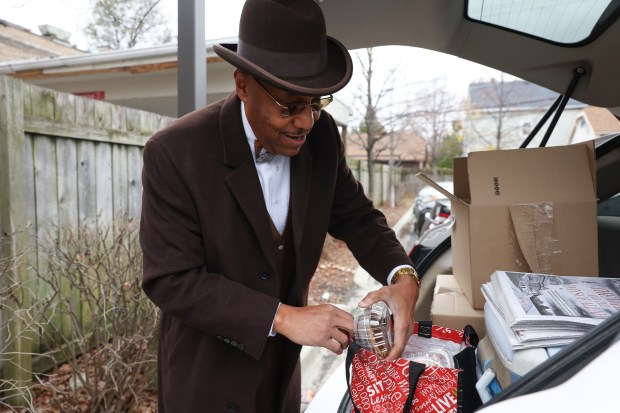 James 40X moves bean pies from a box to a bag for a delivery in the 5100 block of South Western Avenue on Nov. 23, 2024, in Chicago. (John J. Kim/Chicago Tribune)