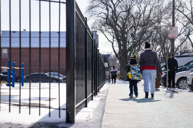 A guardian and child leave Hamline Elementary School after word that U.S. Immigration and Customs Enforcement agents were allegedly denied entry to the school, according to Chicago Public School officials on Jan. 24, 2025. Later, it was learned that it was in fact two Secret Service agents were investigating a threat made regarding TikTok. (Audrey Richardson/Chicago Tribune)