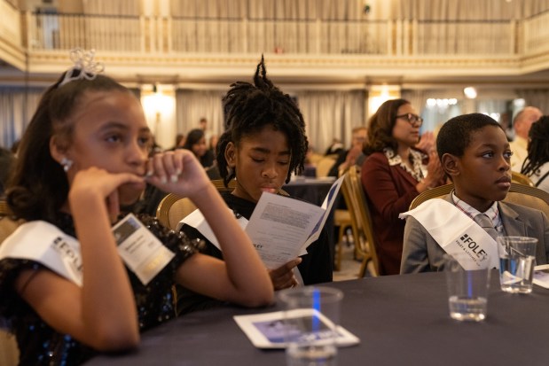 Lariyha Patterson, of Boys and Girls Clubs of Chicago, center, reads the event program before she competes against nine other fourth- and fifth-grade students from Chicago Public Schools and the Boys & Girls Clubs of Chicago during Lardner LLP's Annual MLK Jr. Oratory Competition. (Audrey Richardson/Chicago Tribune)