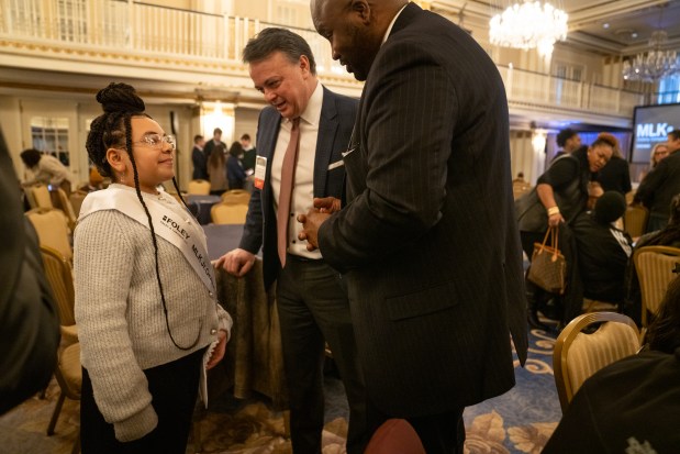 Harmony Daniels, of Wendell Smith Elementary, is congratulated by Illinois Sen. Elgie Sims, right, and Frank Pasquesi, a managing partner at Foley & Lardner LLP, after competing at Lardner LLP's Annual MLK Jr. Oratory Competition at The Drake Hotel. As the first contestant on stage, Daniels captivated the judges and won the competition. (Audrey Richardson/Chicago Tribune)